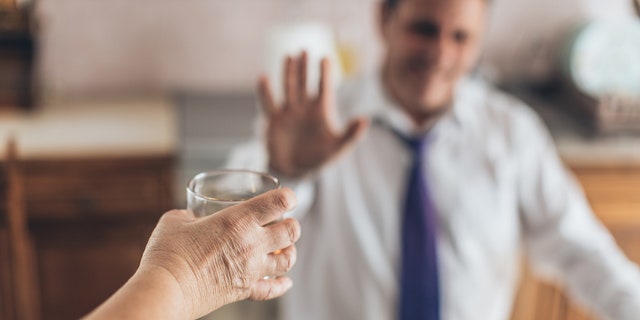 man refuses a drink