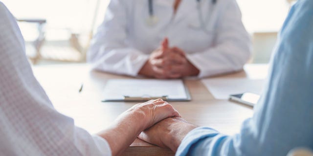 couple holds hands at appointment