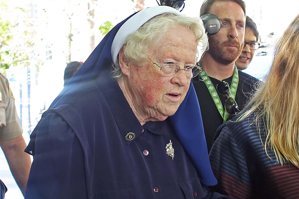 Sisters Catherine Rose Holzman, second left, and Rita Callanan, center, is escorted by businesswoman Dana Hollister, right, out of Los Angeles Superior Court on Thursday, July 30, 2015. 