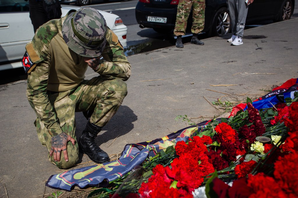 A member of the Wagner group honors the memory of Yevgeny Prigozhin at a spontaneous memorial near the PMC Wagner Center in St. Petersburg. On Wednesday, August 23, 