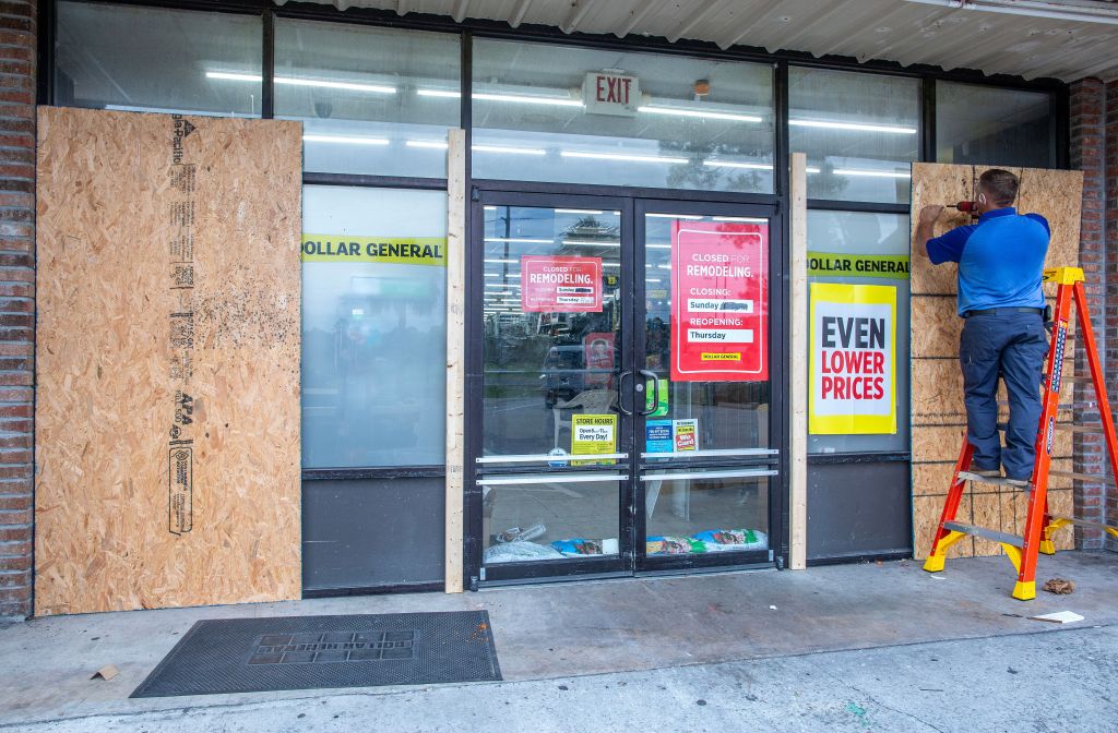 An employee places plywood in front of a store in Cedar Key, FL as Hurricane Idalia makes its way towards mainland Florida.