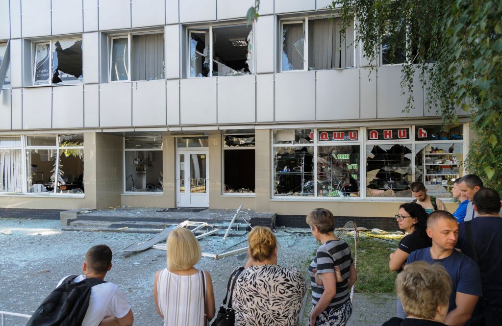 Locals inspect the damage to a building near the impact area of a rocket strike hitting a children's garden in the western Ukrainian city of Lviv, Ukraine, 15 August 2023.