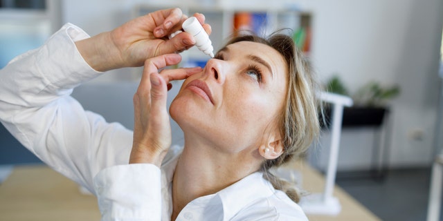 Woman putting in eye drops