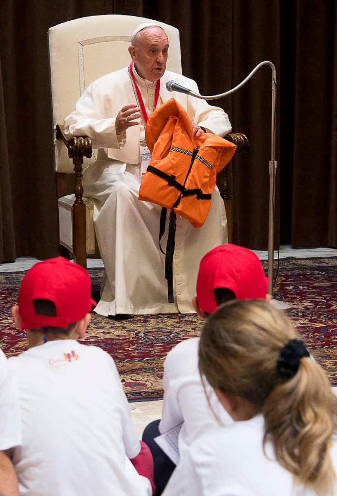 Pope Francis shows the life jacket of a young victim drowned in the Mediterranean sea trying to reach Europe on May 28, 2016 at the Vatican during a meeting with 400 children from the south of Italy, Calabria, including children of migrants.