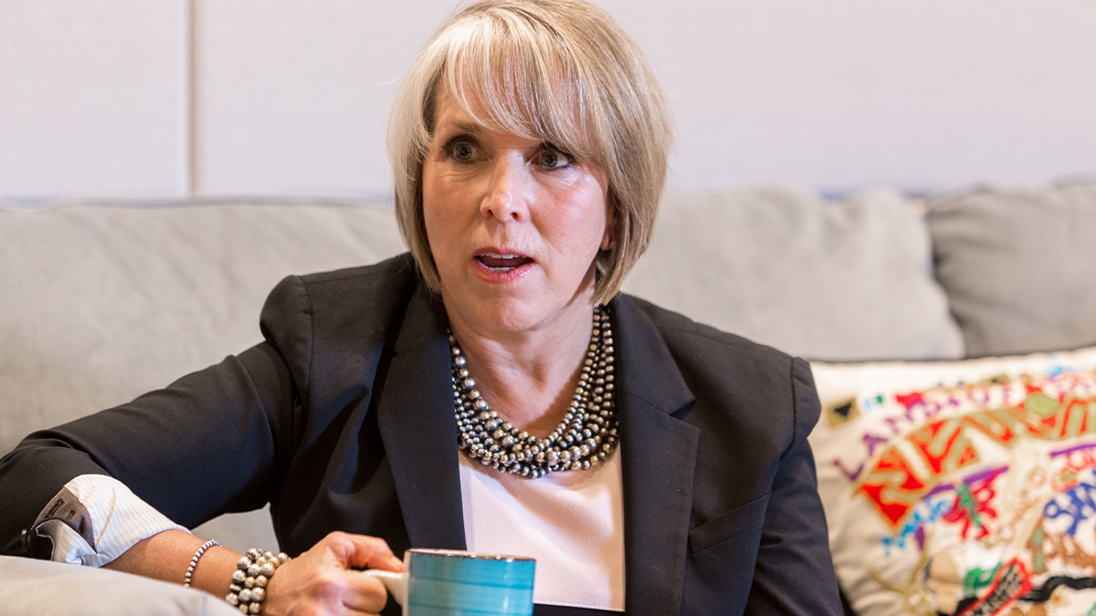 New Mexico governor with coffee cup on couch