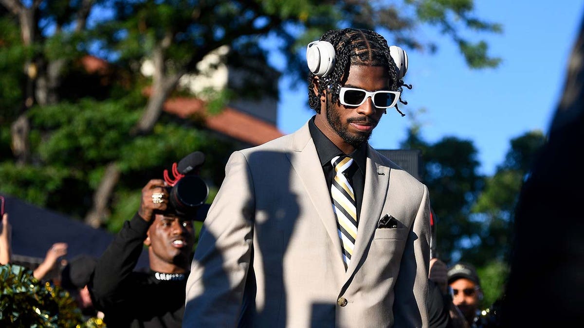 Shedeur Sander walks from the team bus