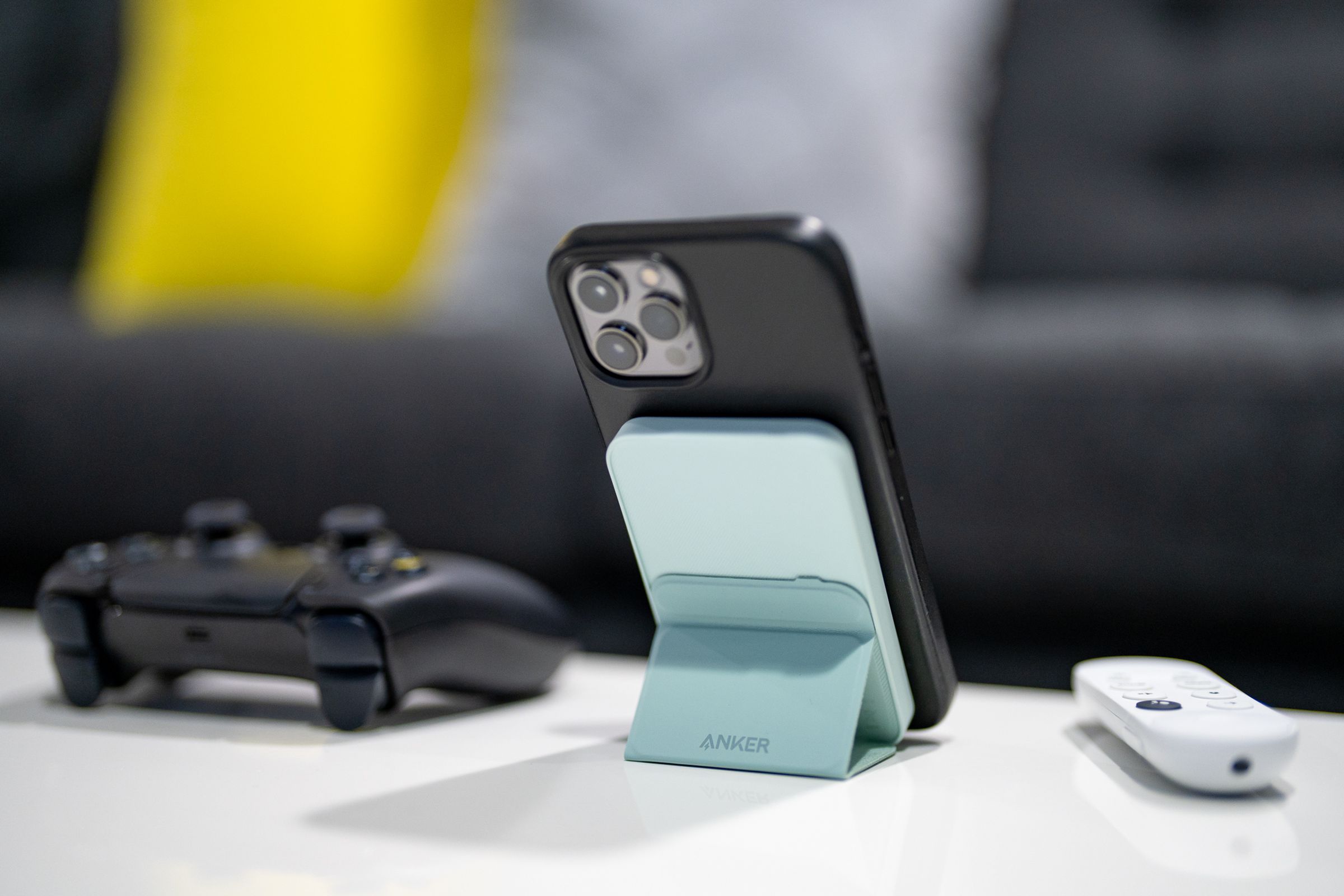 Anker’s 621 Magnetic Battery (MagGo) holding up an iPhone with its kickstand on a desk.