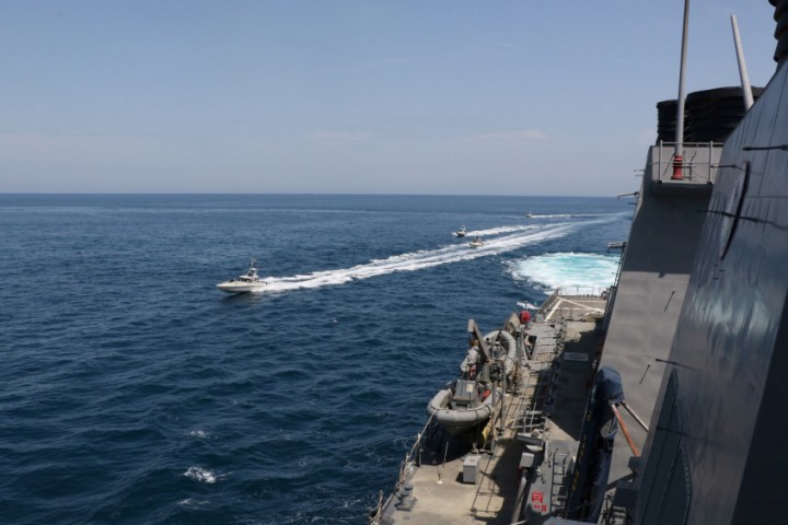 Four Iranian Islamic Revolutionary Guard Corps Navy vessels are seen next to the guided-missile destroyer USS Paul Hamilton in the Gulf. 