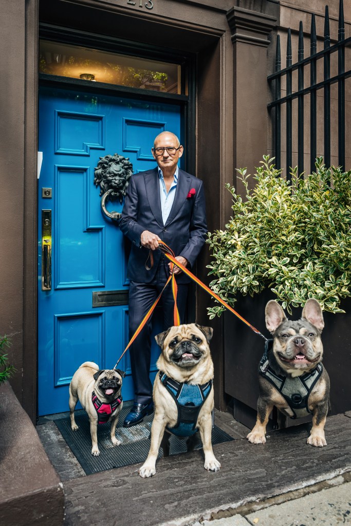 John Demsey with three dogs in front of his blue door