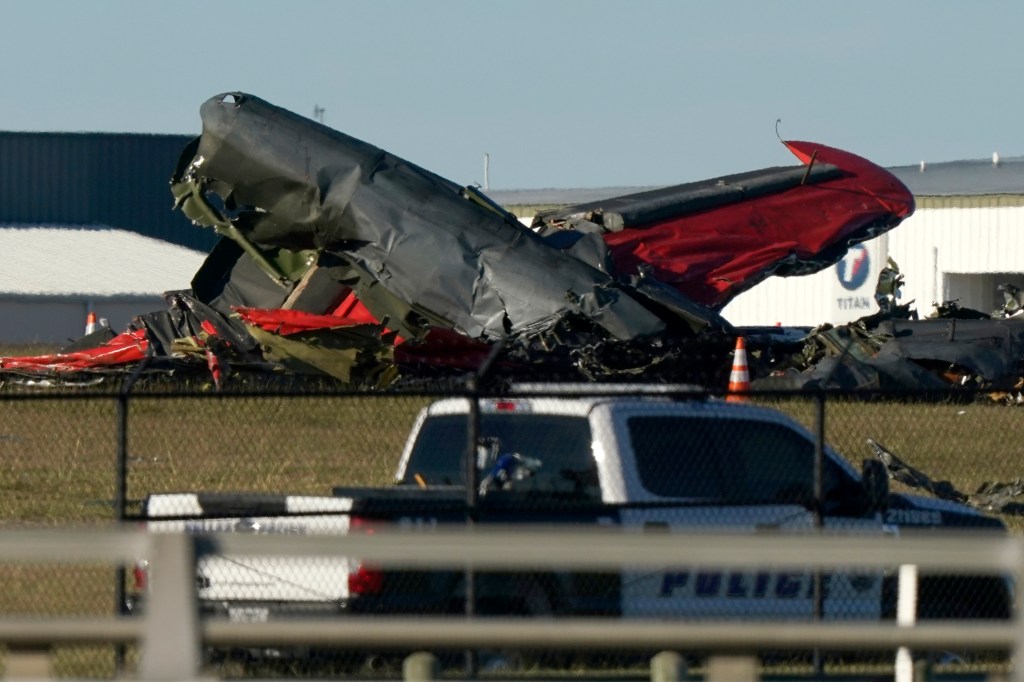 Debris from two planes that crashed during an airshow at Dallas Executive Airport lie on the ground Saturday, Nov. 12, 2022.