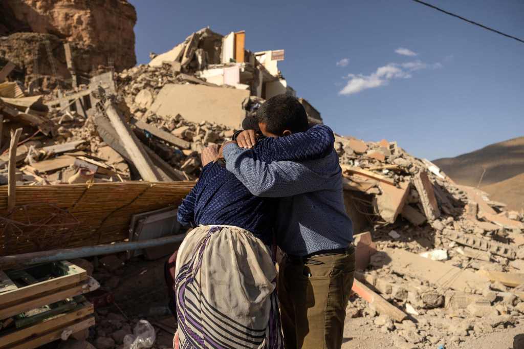 Family members embrace each other near the rubble of collapsed buildings in the village of Imi N'Tala near Amizmiz in central Morocco. 