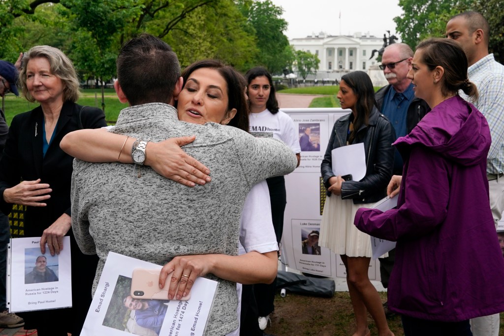 Neda Shargi, sister of Iranian prisoner Emad Shargi, hugs former Syrian hostage Sam Goodwin before a news conference with families of Americans currently being held hostage on May 4, 2022, in Washington. 