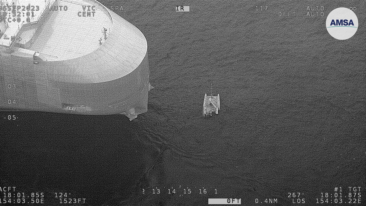 Damaged catamaran next to rescue boat