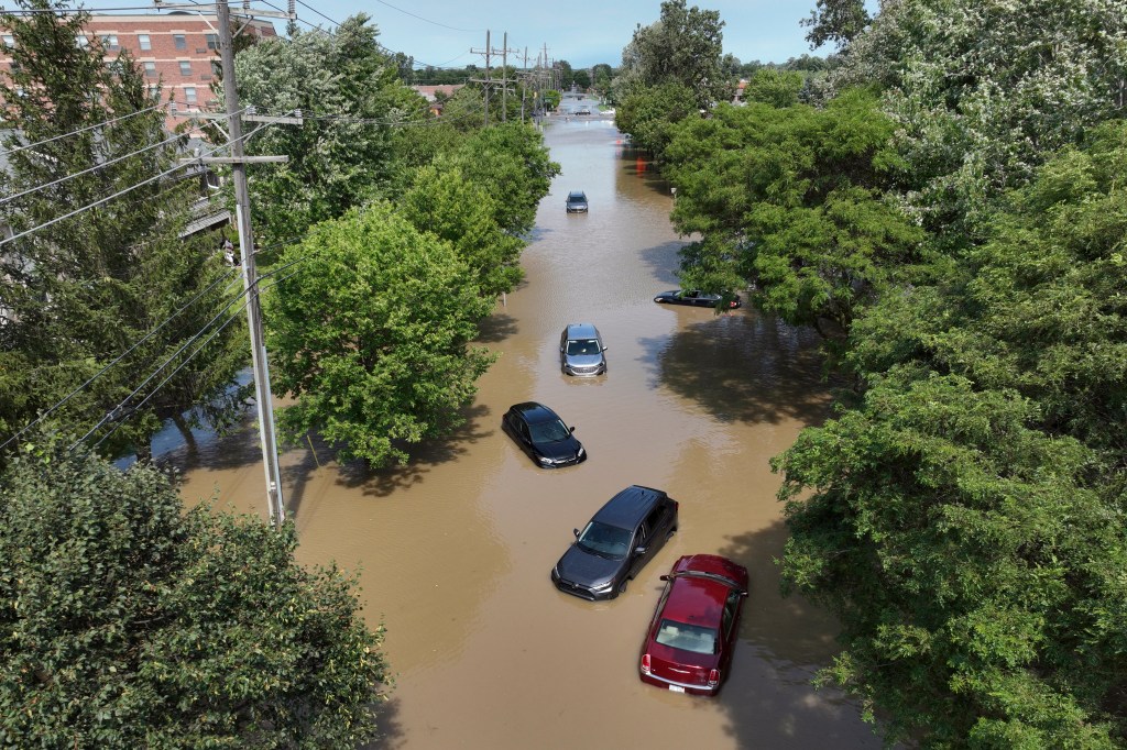 Cars sit stranded in floodwaters on Sheldon Road south of Ford road in Canton, Mich.