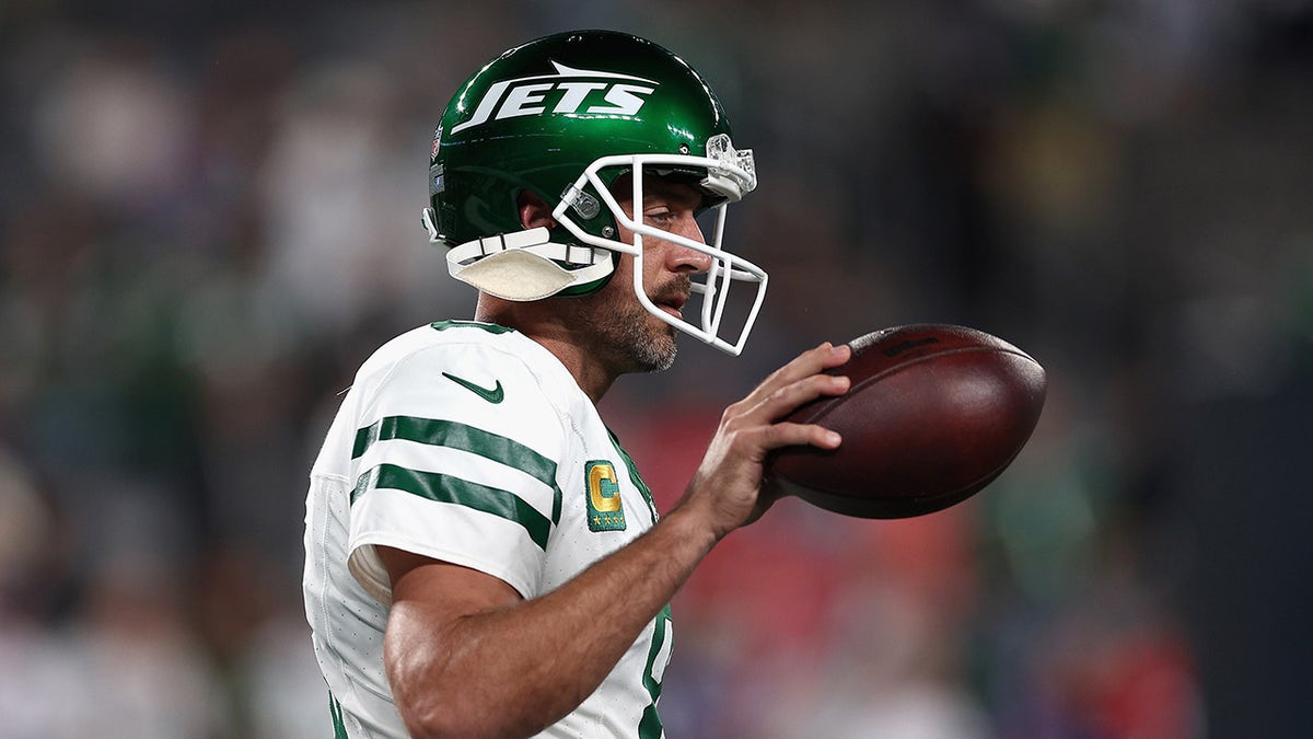 Aaron Rodgers walks on field with ball