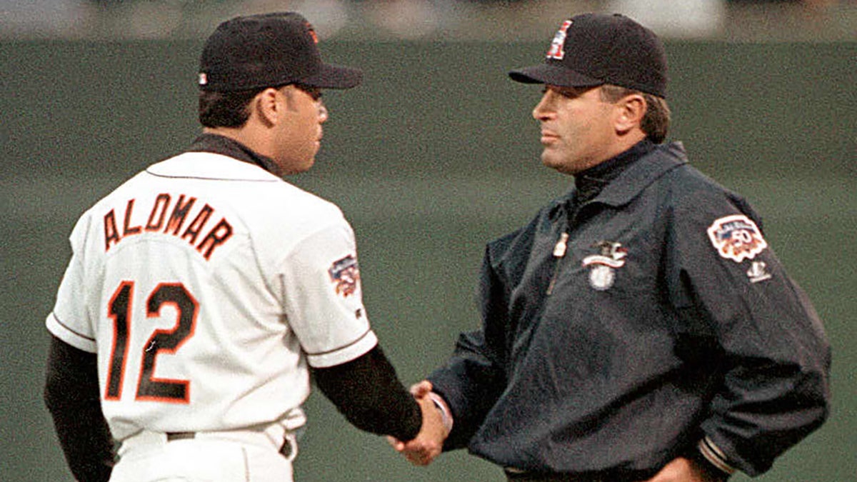 Roberto Alomar shakes hands with umpire John Hirschbeck