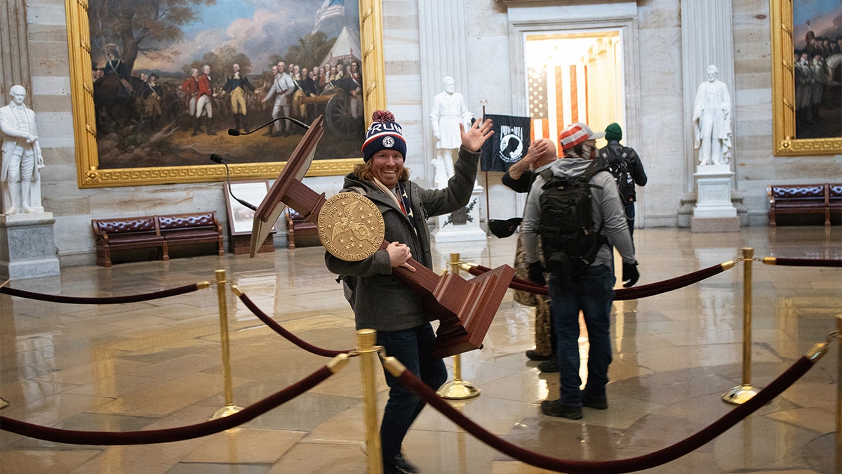 Adam Johnson pictured carrying Nancy Pelosi's lectern