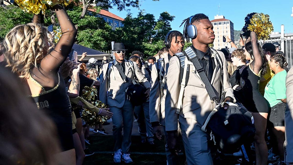 Travis Hunter walks with his teammates