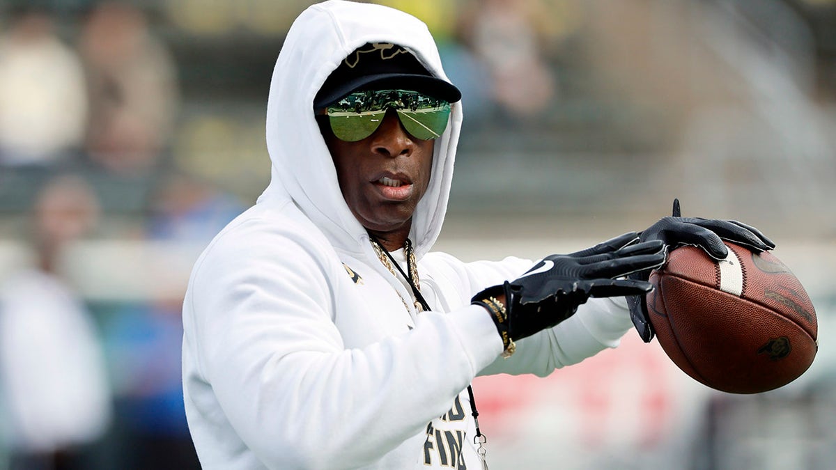 Deion Sanders tosses the ball