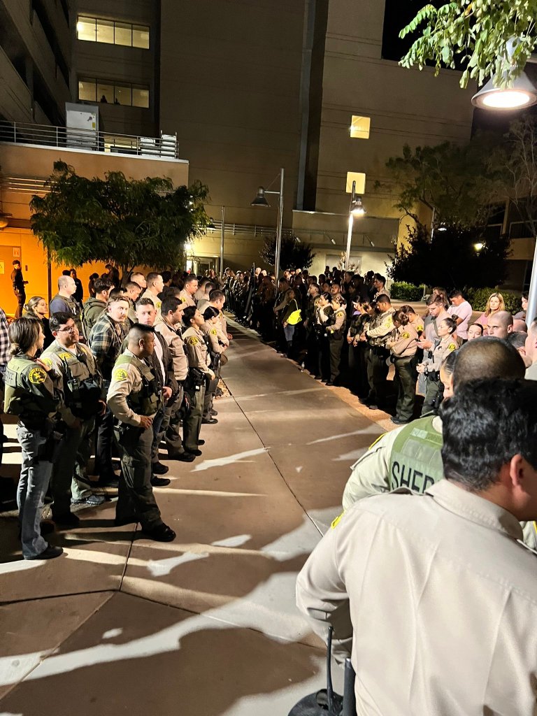 Officers are seen lined up outside the hospital moments before the deputies body was moved to pay their respect.