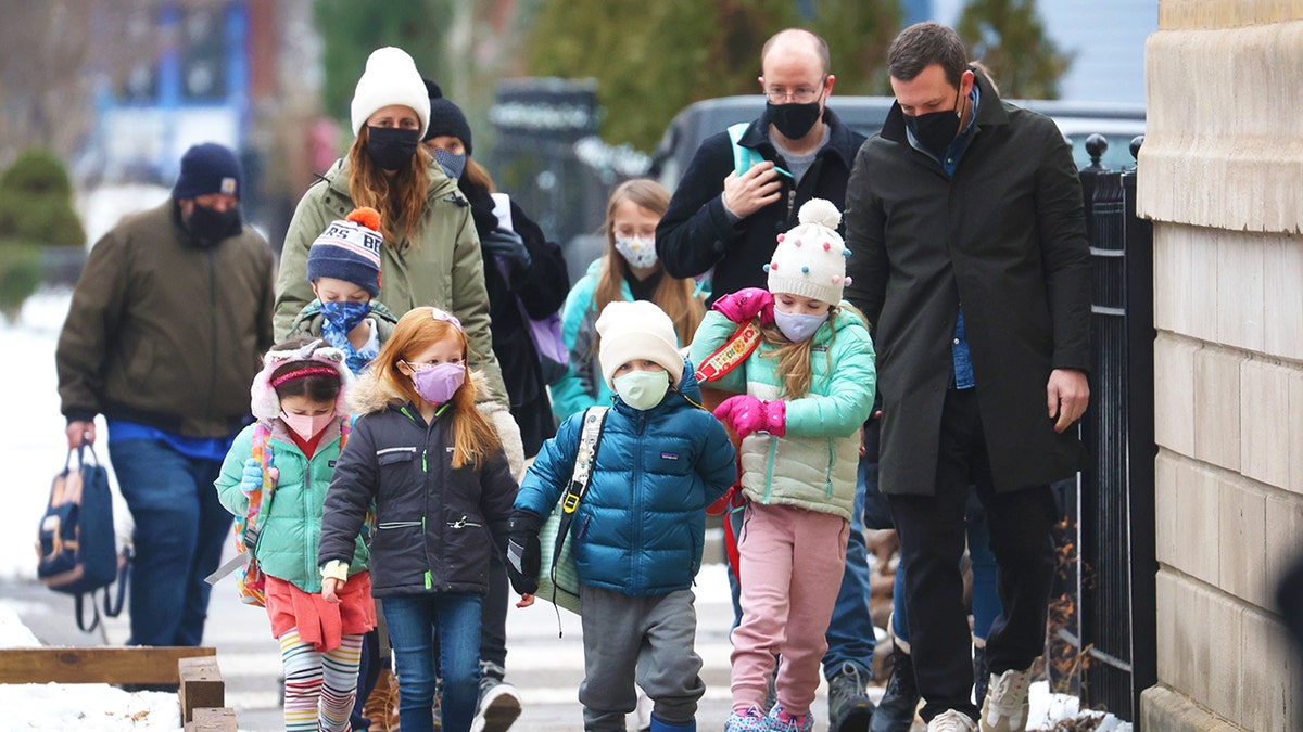 students walk to school outside masked in Jan. 2022 in Chicago