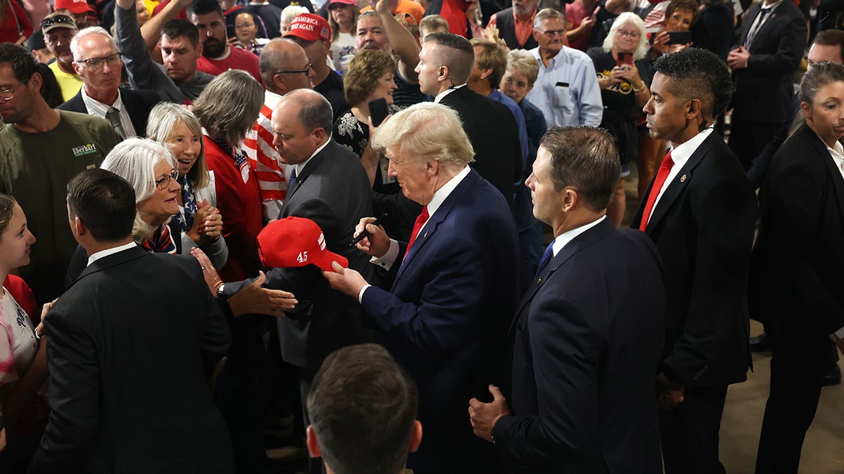 Trump signs a MAGA hat in Iowa