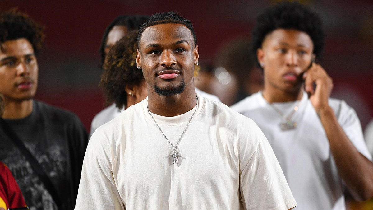 Bronny James looks on during a football game