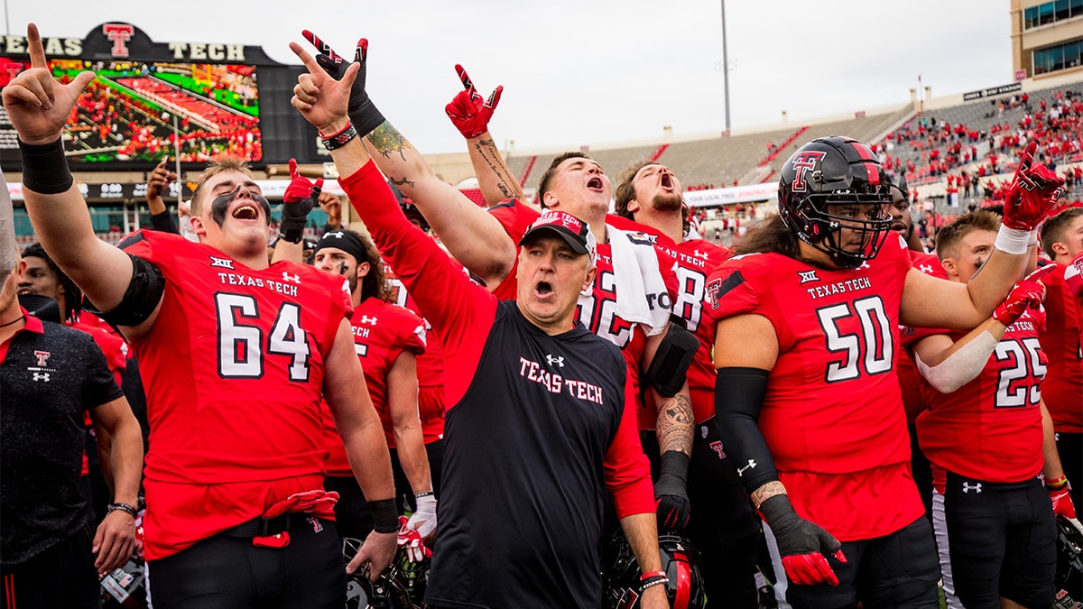 Joey McGuire stands with his players