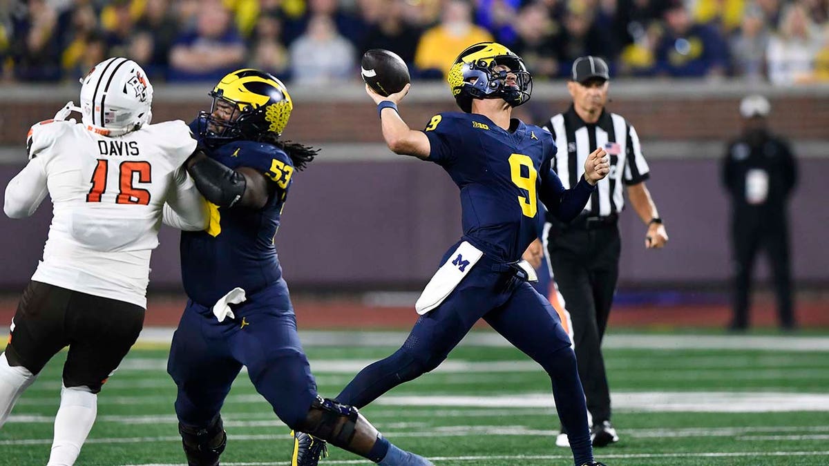 Michigan quarterback throws during a game