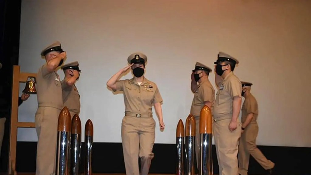 Bils is pictured center during a promotion ceremony for the US Navy.
