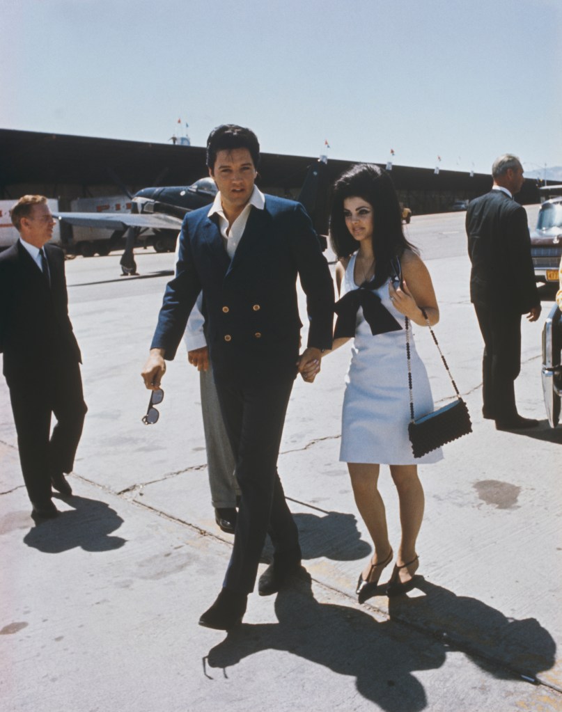 Photo of Elvis and Priscilla Presley holding hands. 