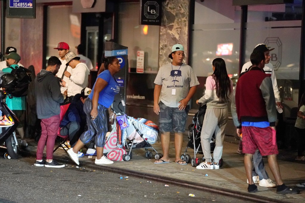 Migrants are seen outside NYC's Roosevelt Hotel this summer. 