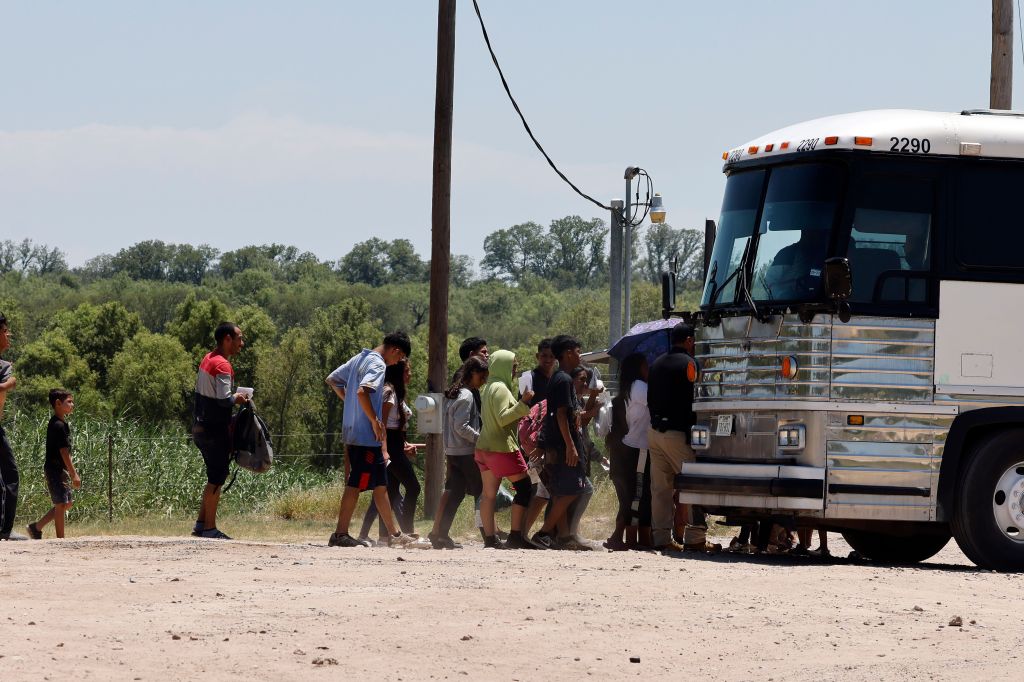 A bus picks up migrants after they crossed the Rio Grande River in Eagle Pass, Texas on July 13. 