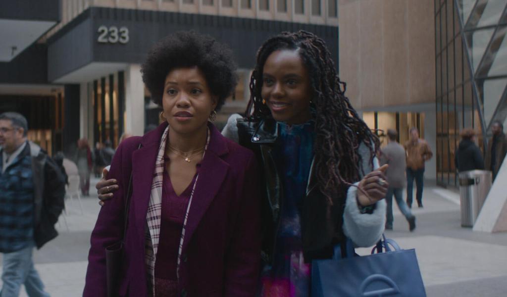 Nella (Sinclair Daniel) and Hazel (Ashleigh Murray) stand together in an office. 