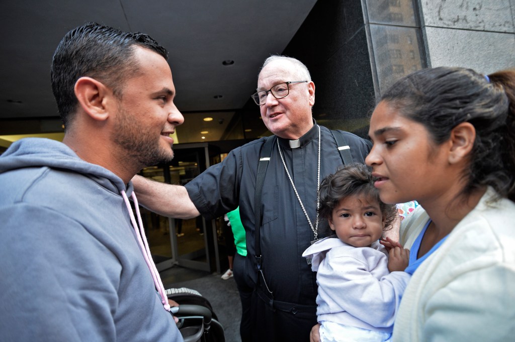 cardinal dolan with migrants