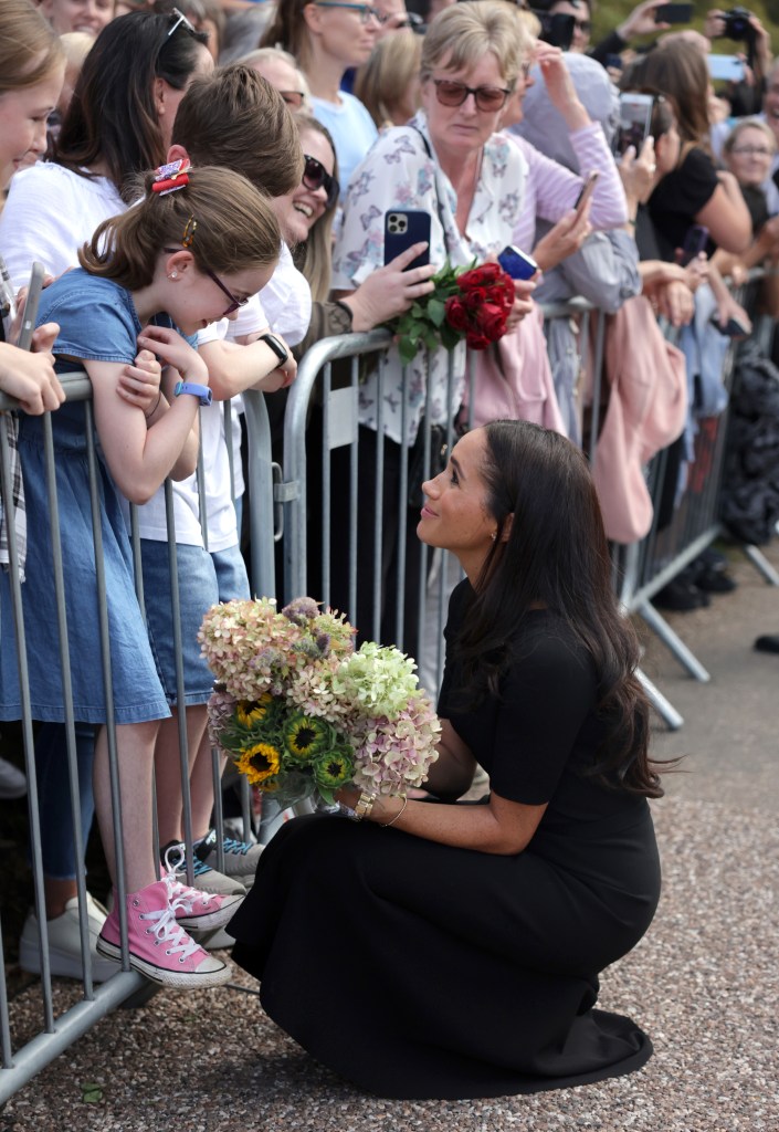 Photo of Meghan Markle talking a young girl. 