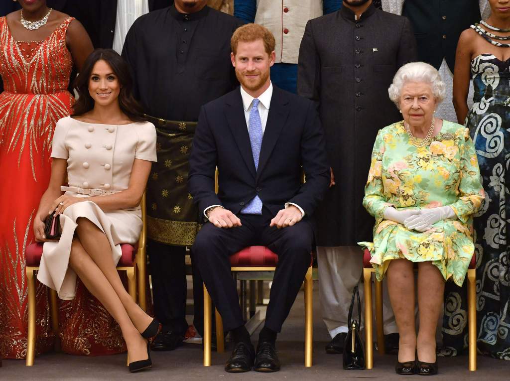 Queen Elizabeth with Prince Harry and Meghan Markle, sitting together in formalwear. 