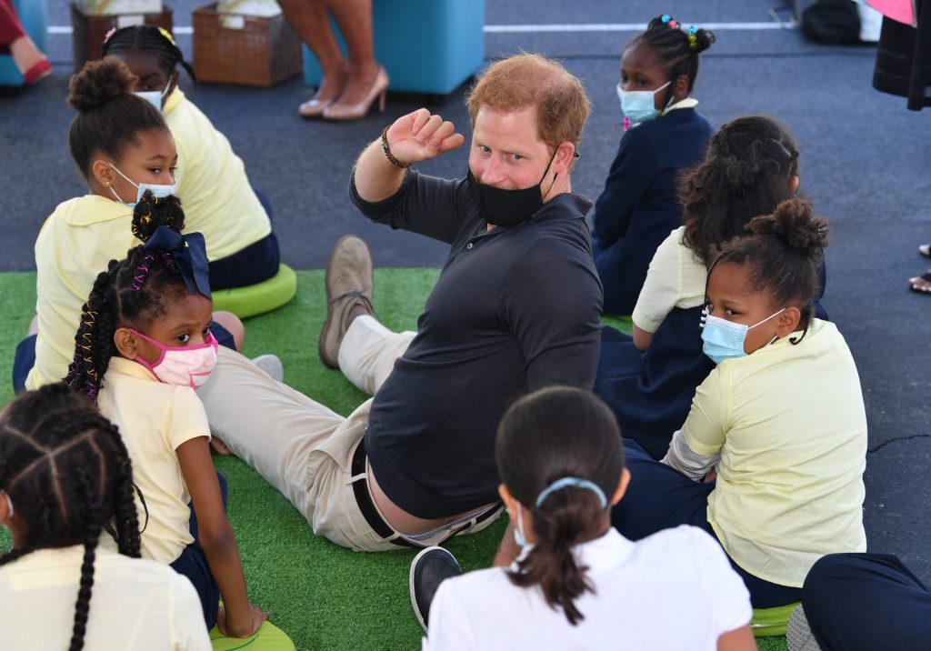 Harry sat cross-legged on the ground close by during Markle's reading.