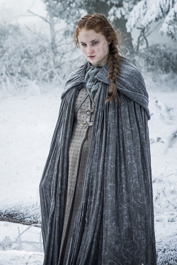 Sansa (Sophie Turner) standing in the show in a cloak looking cold and sad on "Game of Thrones." 
