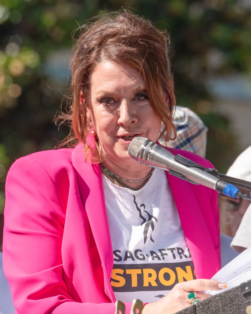 Actress Joely Fisher speaks at a microphone during a SAG-AFTRA union rally.