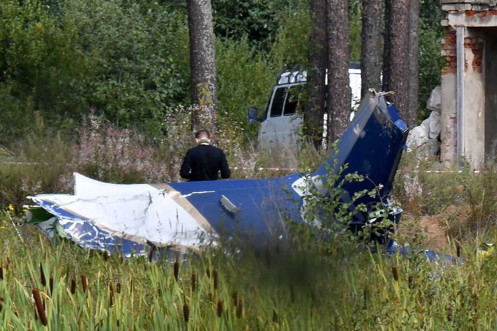 A law enforcement officer works at the site of a plane crash near the village of Kuzhenkino, Tver region, on August 24, 2023