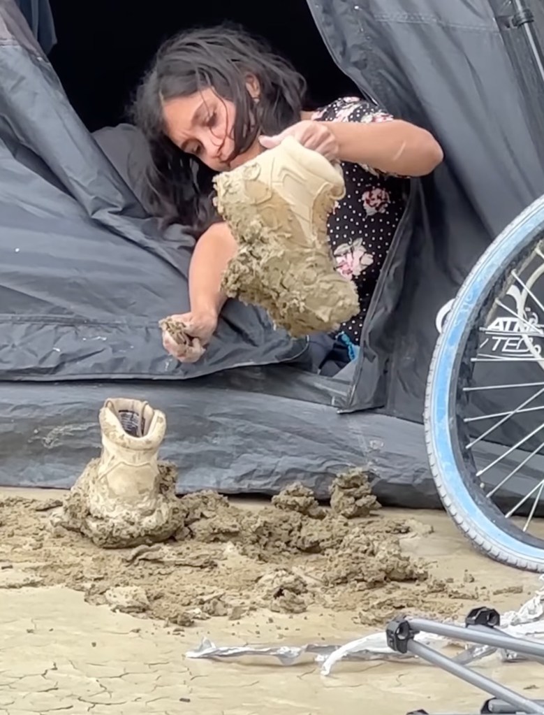 Burning Man participant cleans muddy boots