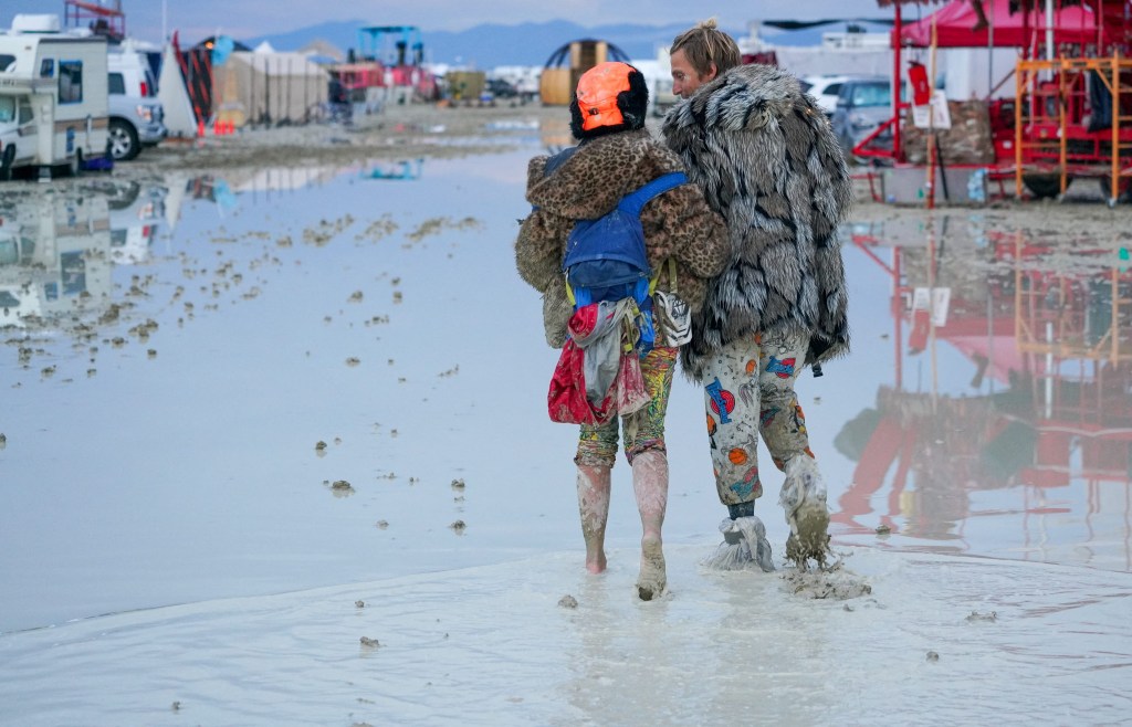 Dub Kitty and Ben Joos, of Idaho and Nevada, walk through the mud.