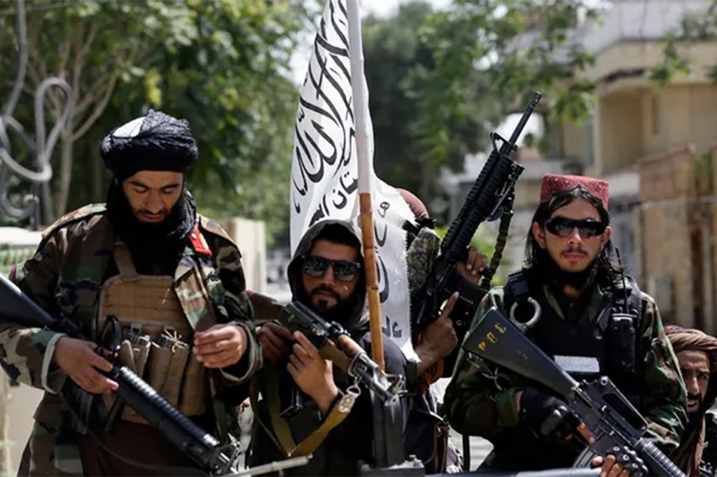 Taliban fighters display their flag while on patrol in Kabul, Afghanistan