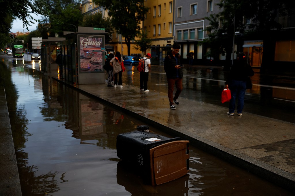 People walked around the flooded streets of Madrid as the rain began to die down on Monday. 