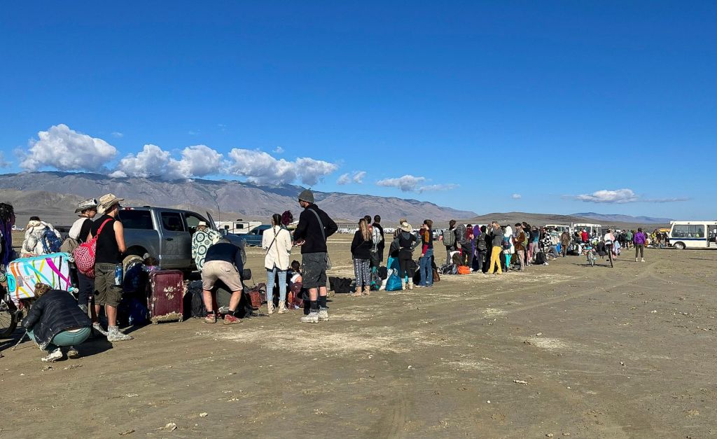 People wait in line for a bus to leave the Burning Man festival in Black Rock City.