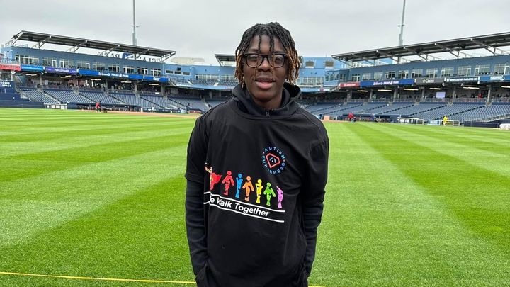 Harris Wolobah standing in an empty football stadium. 