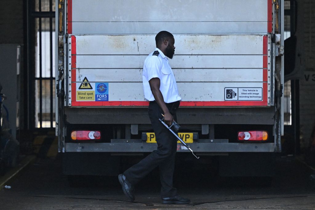 A prison guard walks around the rear of a van at the gates of HM Prison Wandsworth in south London on September 7, 2023, a day after terror suspect, Daniel Abed Khalife escaped from the prison while awaiting tria