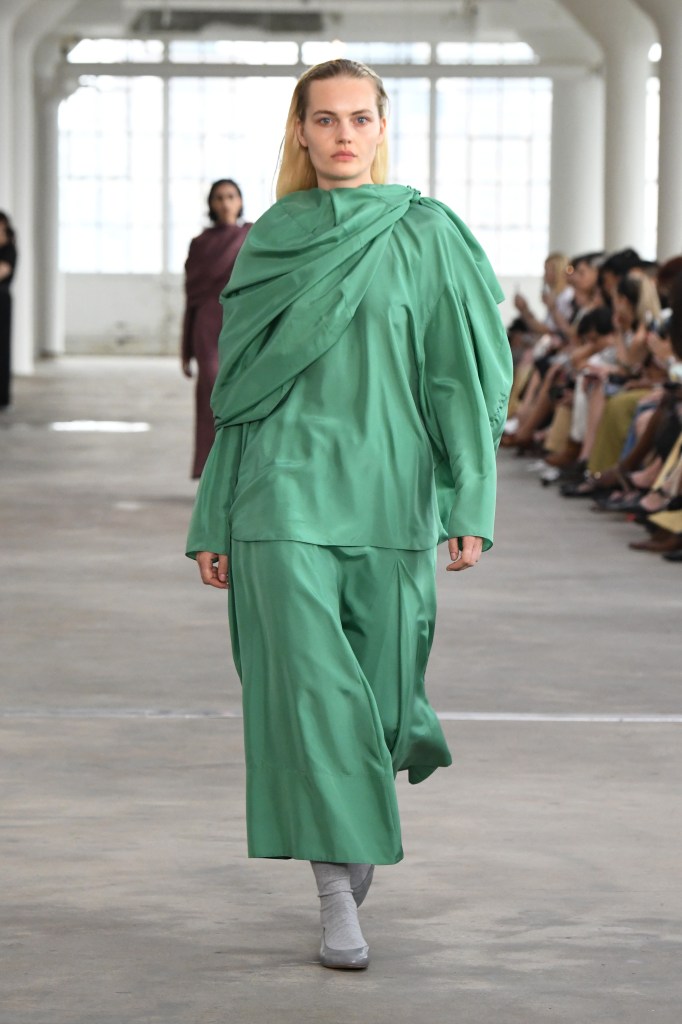 A model in a green Tibi look walks the brand's runway show