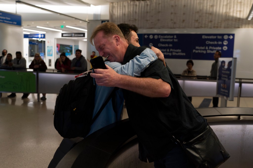 Michael White, a Navy veteran who was jailed in Iran for several years on spying charges, right, hugs Michael's former fellow prisoner and Iranian political activist Mahdi Vatankhah.